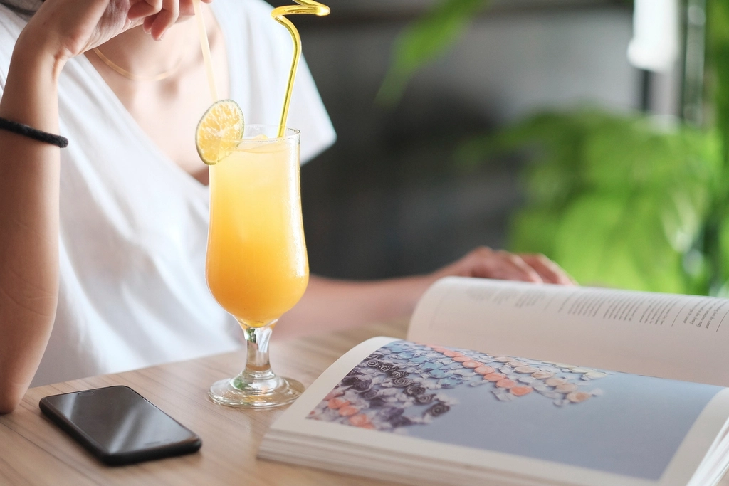 A NewGen Pharmacy customer reading our health guides over a fresh drink