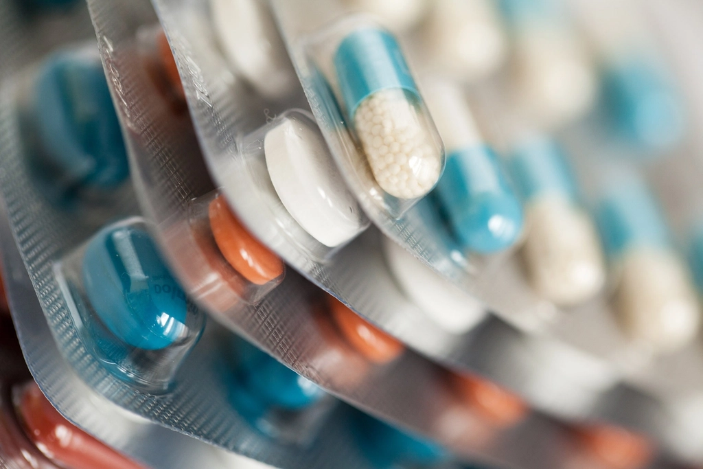 Close-up of blister strips of blue, white and orange antibiotic capsules and tablets