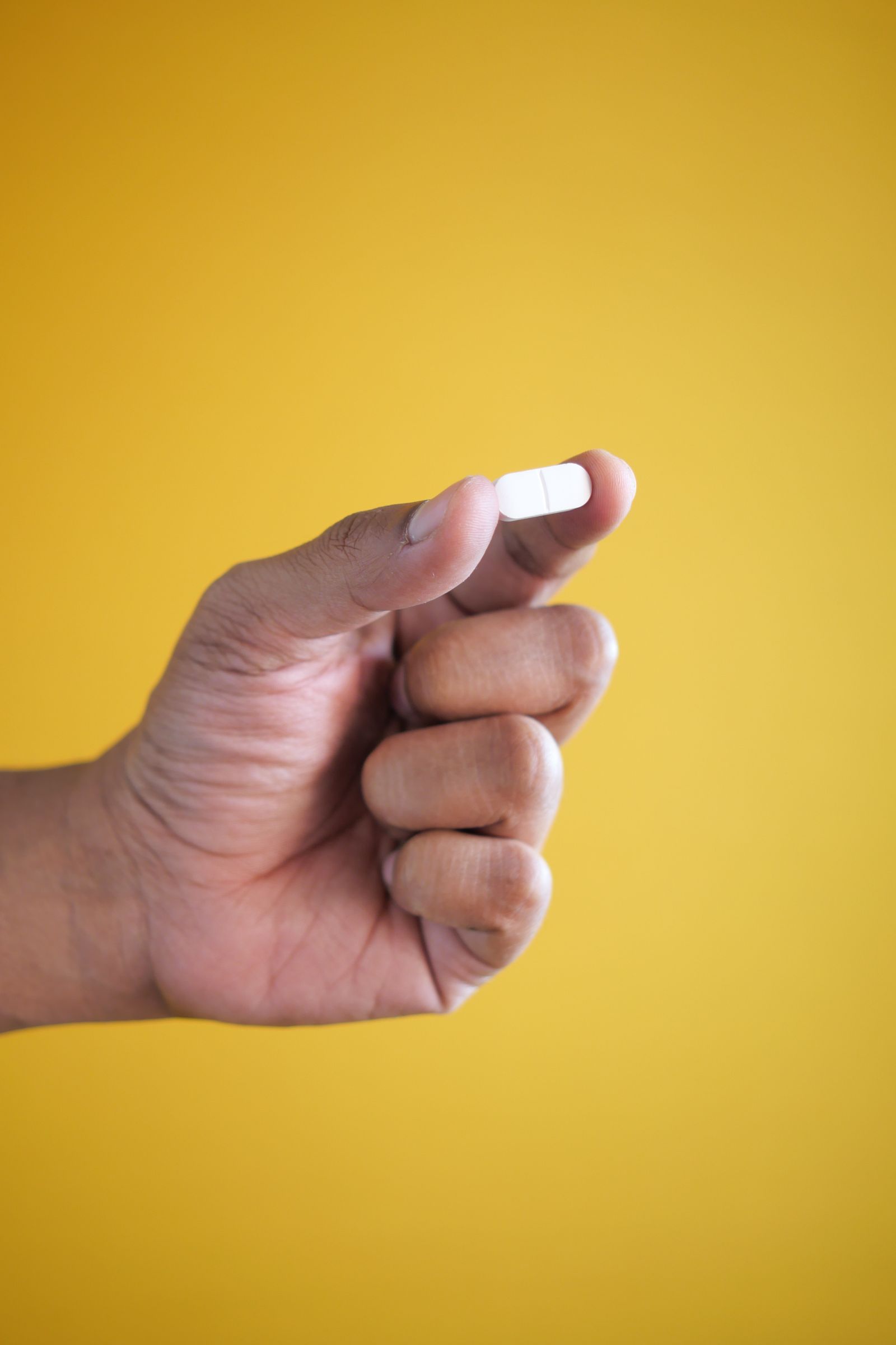 A single once-daily weight-loss tablet held in the hand — needle-free treatment from NewGen Pharmacy